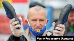 An opposition supporter in Minsk holds a pair of slippers during a rally on May 31 to support a free presidential election in August.