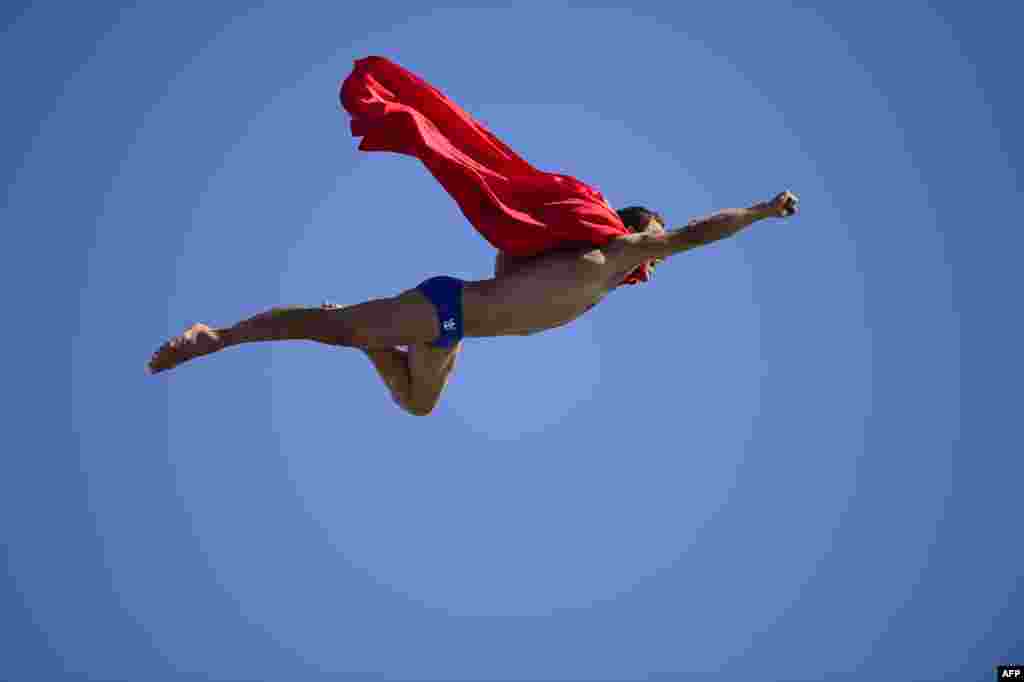 Czech Michal Navratil dives dressed as Superman after the men's high-diving final competition at the FINA World Championships in Barcelona. (AFP/Javier Soriano)