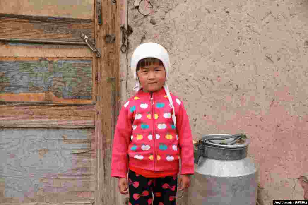 A girl stands next to her house. There are 18 families living in the village. Many have relatives who left to Russia or Kyrgyzstan. Relations between the villagers are very tight, and they celebrate holidays together. If a guest comes to one family, neighbors invite them in, too, or they send over a meal to show respect.
