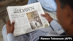 A Pakistan man reads a copy of the English-language Dawn newspaper in Karachi. Reporters Without Borders has condemned the disruption in distribution of Pakistan's oldest newspaper after it published a controversial interview with ousted Prime Minister Nawaz Sharif.