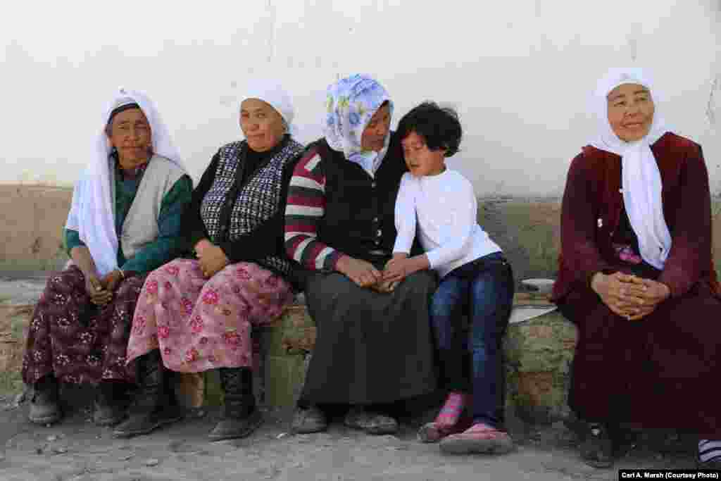 Women and a girl wait for a wedding party in eastern Turkey. Many Kyrgyz marry within their community, but those who go to Turkish universities often marry outsiders and don&#39;t return to the village. More young women than men receive a university education.