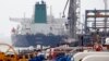 FILE PHOTO - A Panamanian tanker docks at the platform of the oil facility in the Khark Island, on the shore of the Gulf, March 12, 2017