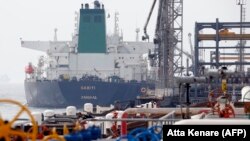 FILE PHOTO - A Panamanian tanker docks at the platform of the oil facility in the Khark Island, on the shore of the Gulf, March 12, 2017