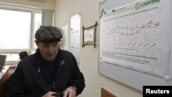 Мужчина в офисе частного накопительного пенсионного фонда. Алматы, январь 2013 года. Частные фонды передали все пенсионные накопления казахстанцев ЕНПФ в 2014 году.