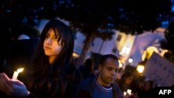 People hold candles during a demonstration on Bourguiba Avenue in central Tunis late on January 22.