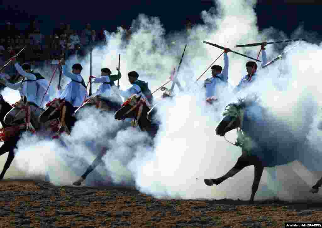 A troupe charges and fire their rifles loaded with gunpowder during a national competition for Tabourida in El Jadida, Morocco. (epa-EFE/Jalal Morchidi)