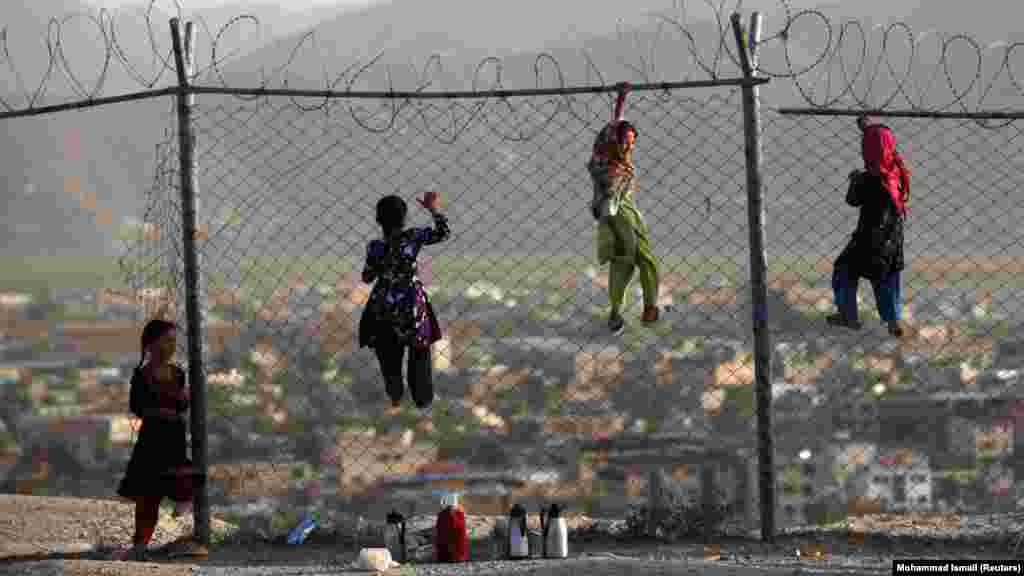 Afghan children climb onto a fence while playing as they sell tea in Kabul. (Reuters/Mohammad Ismail)