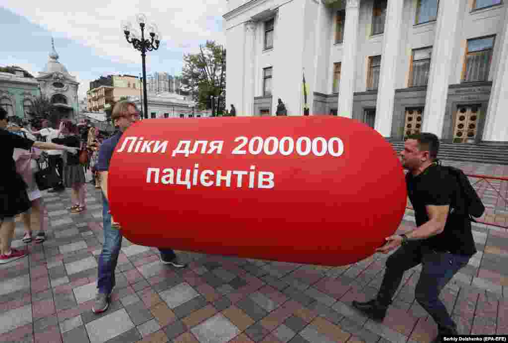 Ukrainian activists carry a giant pill with the slogan, "The Law 10313 is medicine for 2 million patients," during a protest in front of the parliament building in Kyiv. Activists rallied to demand that lawmakers accept a bill regulating the use of cannabis in medicine and scientific research. (epa-EFE/Sergei Dolzhenko)