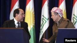 Iraqi Prime Minister Nuri al-Maliki (left) and Iraq's Kurdish regional leader Masud Barzani speak to each other during a joint news conference in Irbil in June.