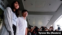 جاشوآ وونگ و اگنس چو به برگزاری اجتماع غیرقانونی در مقابل مرکز پلیس در روز ۲۱ ژوئن متهم شده‌اند