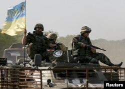 Members of the Ukrainian armed forces ride on an armored personnel carrier as they patrol area near Artemivsk in eastern Ukraine on June 4.