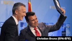 NATO Secretary-General Jens Stoltenberg (left) and Macedonian Prime Minister Zoran Zaev pose during a ceremony marking NATO's decision to invite Macedonia to join, in Brussels on July 12.