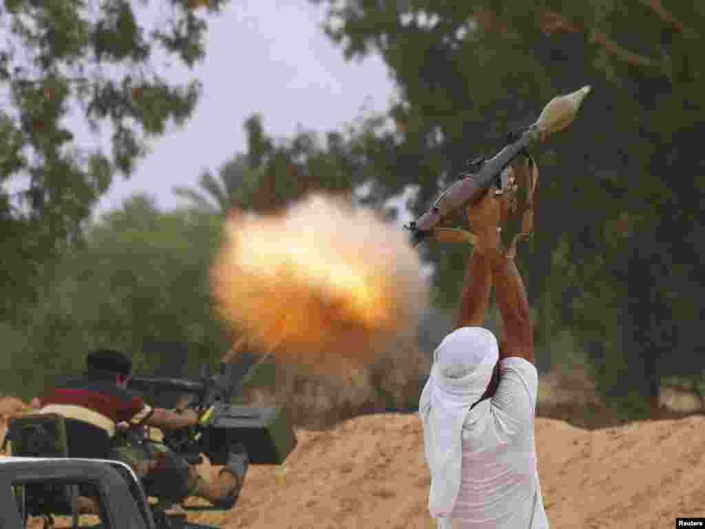 A fighter for Libya's anti-Qaddafi forces fires an RPG-7 during fighting in an area about 1 kilometer from the center of Sirte on October 3. (Photo by Anis Mili for Reuters)