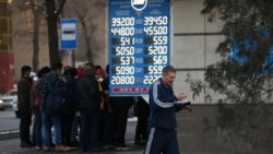 Прохожие на фоне табло с курсами валют. Алматы, 10 марта 2020 года.