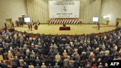 Lawmakers take the oath of office during the first session of Iraq's new parliament on June 14 in Baghdad.