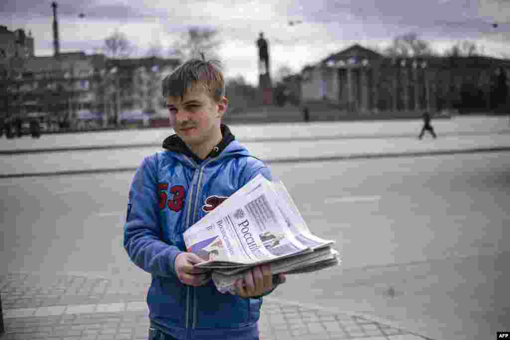 Ukraine -- Crimea - A Crimean man is handing out for free "Russian newspaper" paper in Simferopol's Lenin Square on March 19, 2014.