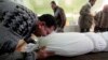 A man sobs over the shrouded body of his son, who was killed by a car-bomb attack, before his burial at a cemetery in Najaf, south of Baghdad, on January 31. 