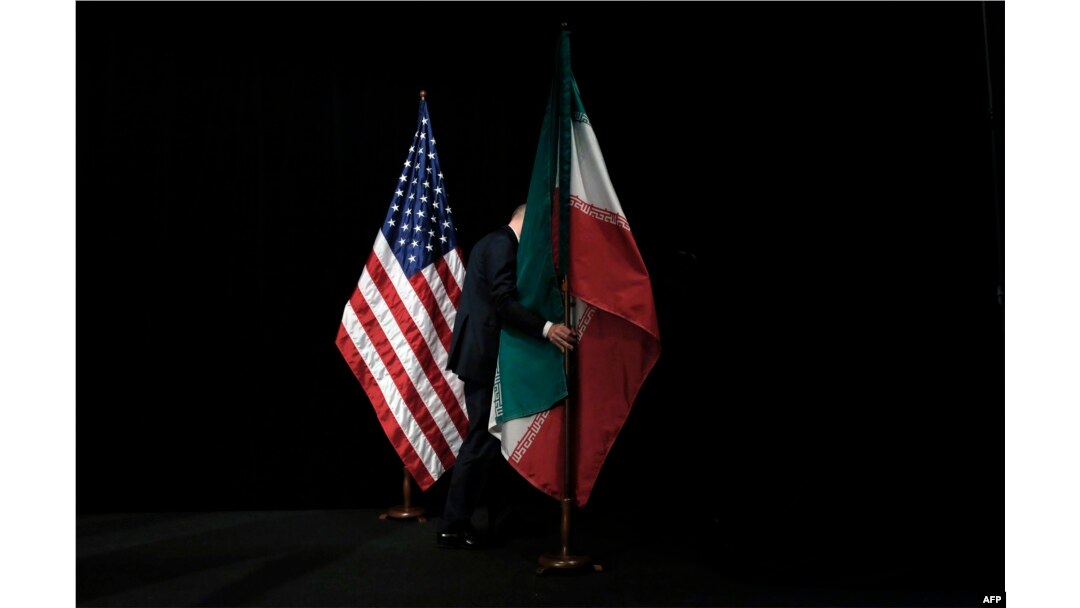 A worker removes Iranian and U.S. flags following a round of talks on Tehran's nuclear program in Vienna in July 2015.