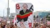 Минскиде митингчилердин бири кармап чыккан Лукашенконун шакаба сүрөтү.