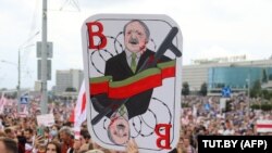 Минскиде митингчилердин бири кармап чыккан Лукашенконун шакаба сүрөтү.