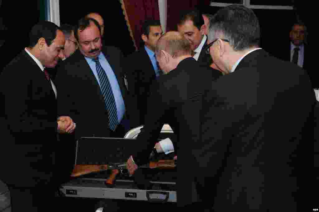 Egyptian President Abdel Fattah Al-Sisi (left) receives a Kalashnikov rifle as a gift from Russian President Vladimir Putin (second right) in Cairo on February 9. (epa)