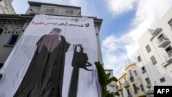 بنر اعتراضی که بنسلمان را با اره برقی نشان میدهد