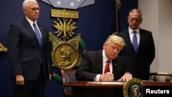 U.S. President Donald Trump signs his first executive order on immigration on January 27.