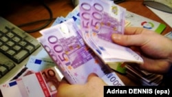 A cashier counts out 500 Euro notes in The American Express bureau de change on Haymarket in London 12 December 2001.