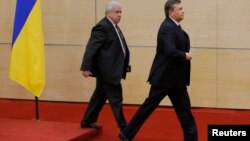 Свергнутый президент Украины Виктор Янукович (справа) покидает пресс-конференцию в Ростове-на-Дону. 28 февраля 2014 года.