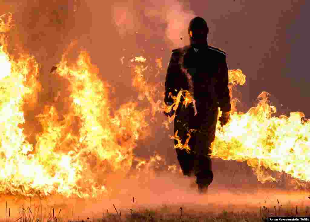 Stunt performer Viktoria Kolesnikova takes part in endurance testing of a new army watch, presented by Russia's Rostec Corporation. The watch is intended to be resistant to high impacts, electromagnetic effects, electronic warfare actions, and the aftereffects of a nuclear blast. The watch is to be included in the combat gear for Russia's ground, airborne, coastal defense, and other forces. (TASS/Anton Novoderezhkin)
