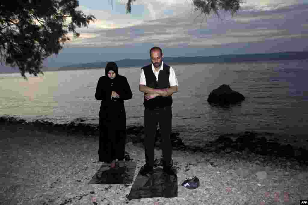 Migrants pray after arriving on the shores of the Greek island of Lesbos aboard an inflatable dinghy across the Aegean Sea from Turkey. (AFP/Angelos Tzortzinis)