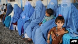 Afghan women and their children are pictured at a UNHCR registration center on the outskirts of Peshawar, Pakistan, in June.