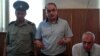 Azerbaijani journalist Eynulla Fatullayev stands trial for possession of drugs in 2010. He was found guilty of the charges, which Amnesty International described as "fabricated," and sentenced to 2 1/2 years imprisonment.