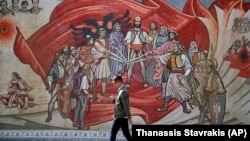 Një person kalon pranë një murali me motive kombëtare shqiptare në Shkup të Maqedonisë së Veriut. Fotografi nga arkivi. 