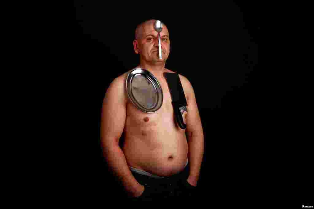 Nermin Halilagic, 38, poses in Bihac, Bosnia-Herzegovina. Halilagic discovered earlier this year that he had the unusual ability to attach items to his body using what he says is a special energy radiating from his body. Without making any special preparations, he says he is able to hold on to spoons, forks, knives, and other kitchen appliances, as well as nonmetal objects like remote controls, plastic items, and cell phones. (Reuters/Dado Ruvic)