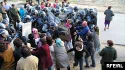 Полицейлер жолдарын бөгеген әйелдер шебін бұзып өтті. Алматы, Шаңырақ ауылы, 14 шілде 2006 жыл. 