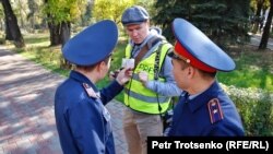 Полицейские проверяют документы у журналиста, прибывшего к месту анонсированной протестной акции. 26 октября 2019 года.