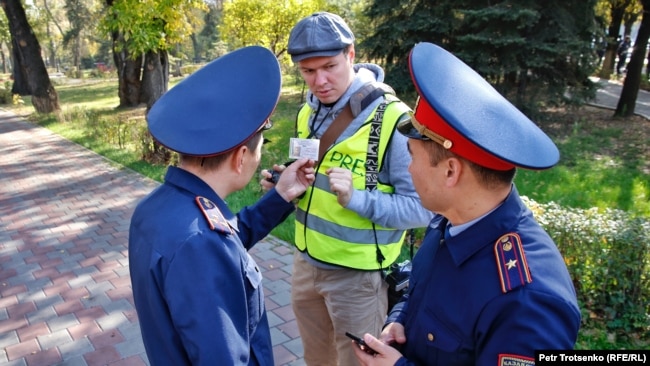 Полицейские проверяют документы у журналиста, прибывшего к месту анонсированной протестной акции. 26 октября 2019 года.