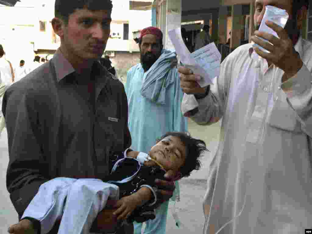 Pakistan -- A girl who was injured in a landmine blast that hit a passenger bus in tribal region of Mohmand, is rushed to a local hospital in Peshawar, 23Oct2009 - Caption: epa01907884 A girl who was injured in a landmine blast that hit a passenger bus in Pakistan's tribal region of Mohmand, is rushed to a local hospital in Peshawar, the capital of North-West Frontier Province (NWFP) Pakistan on 23 October 2009. At least 18 civilians including women and children died when a landmine exploded next to a bus in Mohmand tribal agency.