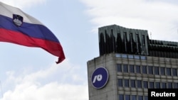 Slovenia - Slovenia's national flag flutters next to Nova Ljubljanska Banka (NLB) building in Ljubljana, 23Jul2012