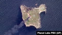 На супутниковому знімку, зробленому Planet Labs PBC, видно дим, який піднімається після ударів армії України по російських позиціях на острові Зміїний у Чорному морі, 6 травня 2022 року