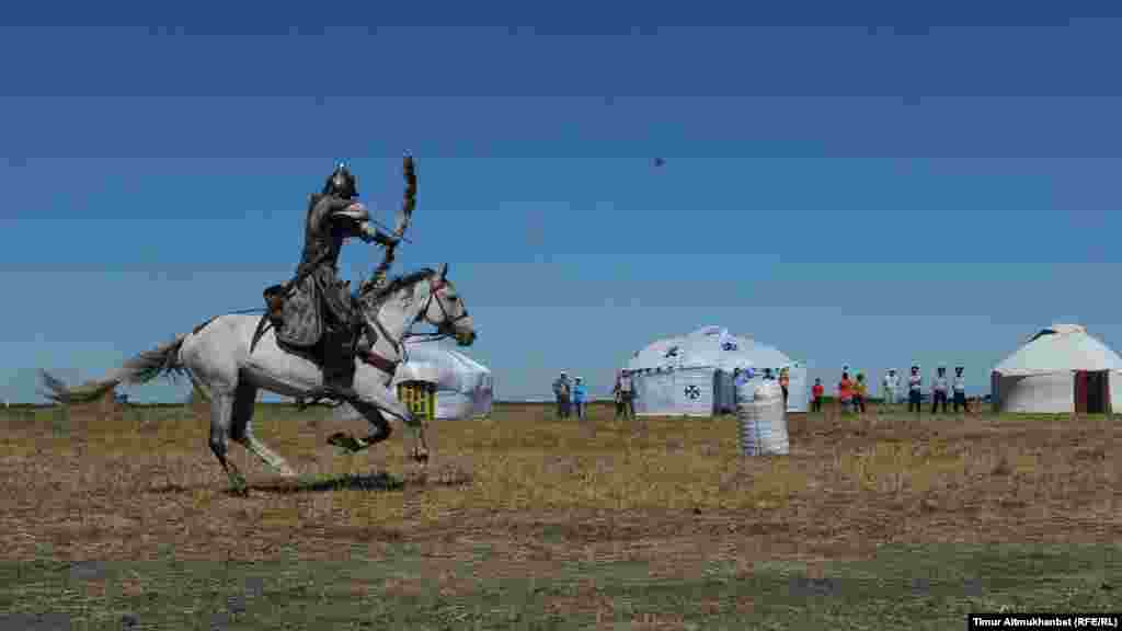 Алматылық Nomad каскадерлер тобының өнерпаздары ат үстінде өнер көрсетті. Суретте: ат үстінде келе жатып садақтан жамбы ату жарысы.