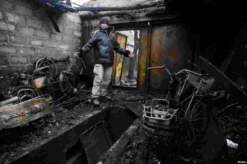 A local resident gestures while standing in his garage, which was damaged during the recent exchange of fire between Ukrainian government forces and Russia-backed separatists, on the outskirts of Donetsk, Ukraine. (Reuters/Alexander Ermochenko)