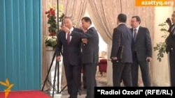 Бывший помощник президента Казахстана Нурсултана Назарбаева Булат Утемуратов (второй слева) пытается сфотографироваться с ним на селфи. Бурабай, 16 октября 2015 года.