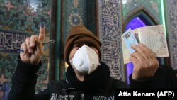 Парламент сайлауына дауыс беруге келген адам құжаттарын көрсетіп тұр. Тегеран, 21 ақпан 2020 жыл.