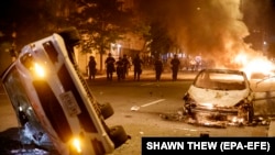 Protests Washington -- Police officers advance on protesters after they set three cars on fire during a demonstration over the death of George Floyd, near the White House in Washington, DC, USA, 31 May 2020. 