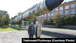 Stanislav Yus (right) stands with Christopher Miller outside Ukraine's Yuzhmash rocket factory.