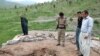 Kurdish security officers look at the damage to a roof following suspected Iranian shelling on Narmalas, close to the Iran-Iraq border.