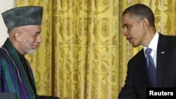 Afghan President Hamid Karzai (left) has questioned U.S. President Barack Obama's (right) announced deadline to start withdrawing U.S. troops.