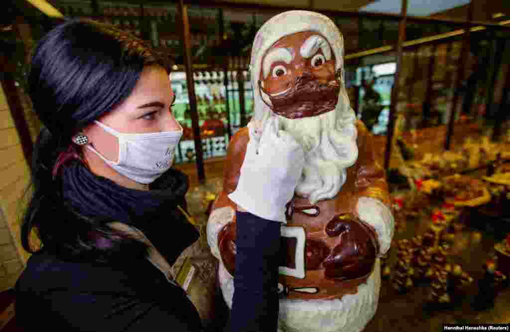 Співробітниця готує шоколадного Санта-Клауса в масці на шоколадній фабриці Confiserie Felicitas в Горнові (Hornow-Wadelsdorf), неподалік від Шпрембергу, Німеччина, 4 грудня 2020 року